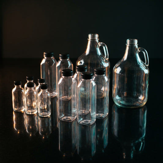 Empty reusable containers: 2 oz shot bottles, juice bottles, and gallon jugs